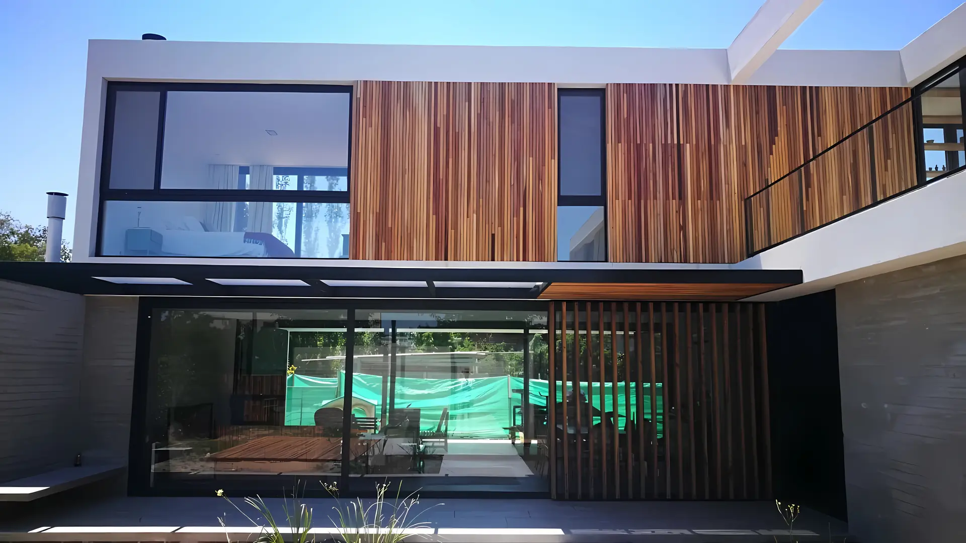 Vivienda moderna con ventanales de aluminio y revestimiento de madera