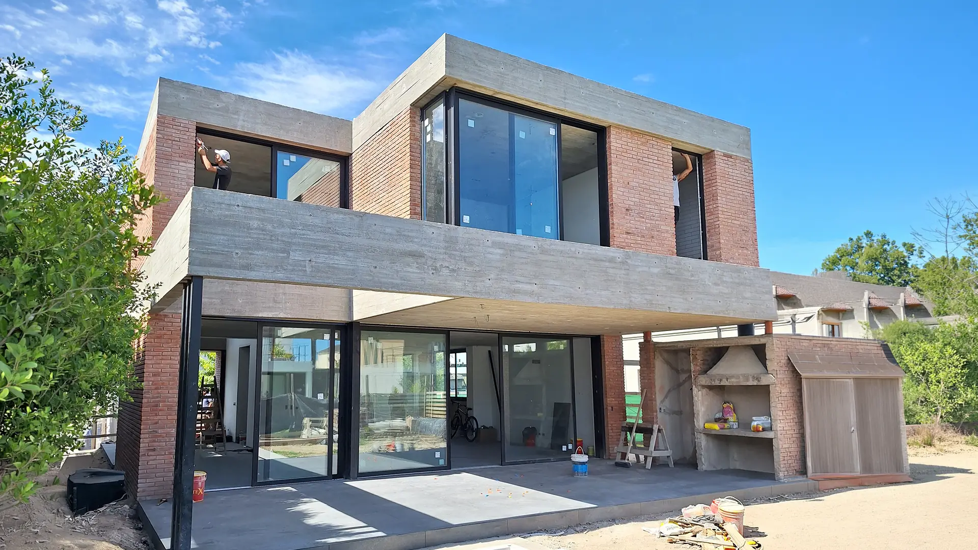 Casa de ladrillo y hormigón con carpintería de aluminio a medida